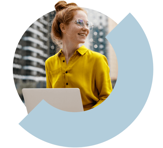 Mulher sorrindo e trabalhando ao ar livre em um notebook.