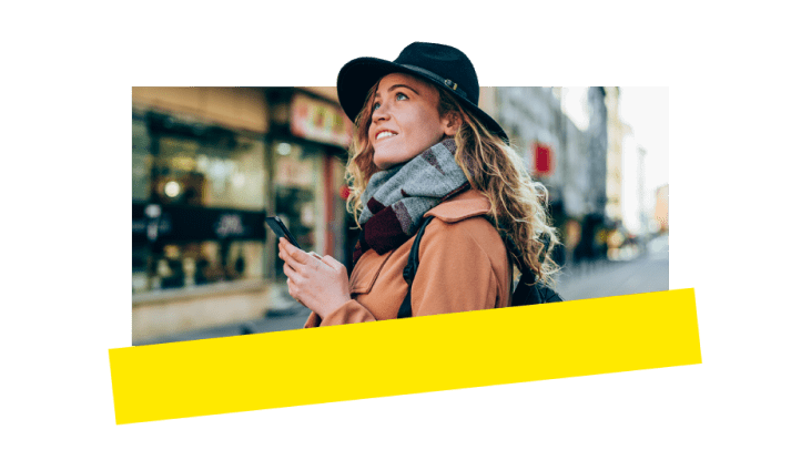 A woman using GoTo Connect on her phone while out in the city.