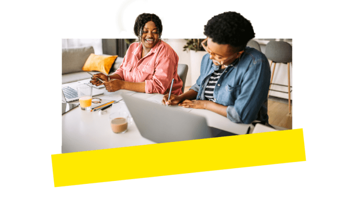 Twee collega’s die lol hebben terwijl ze samenwerken via VoIP-tools.